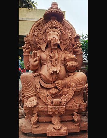 Traditional Lord Ganesha statue in sandstone with intricate trunk and crown details, handcrafted for spiritual blessings