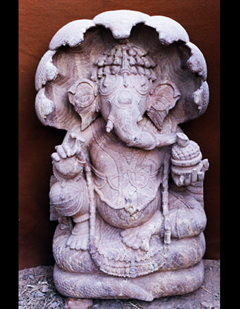 Traditional Vighnaharta Ganesha idol with modak sweets and detailed costume carving
