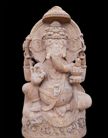 Sandstone Ganesh sculpture in dancing pose with flowing garments and ornamental base design