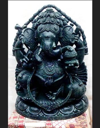 Intricate green stone artwork featuring a dancing figure with dynamic movement and flowing garments