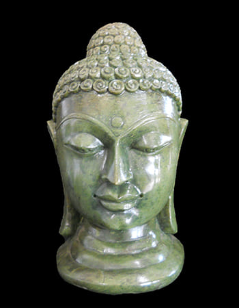 Artistic green stone carving of a celestial figure with wings and heavenly ornaments
